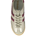 The top view of a golden Gola sneaker with burgundy stripes.