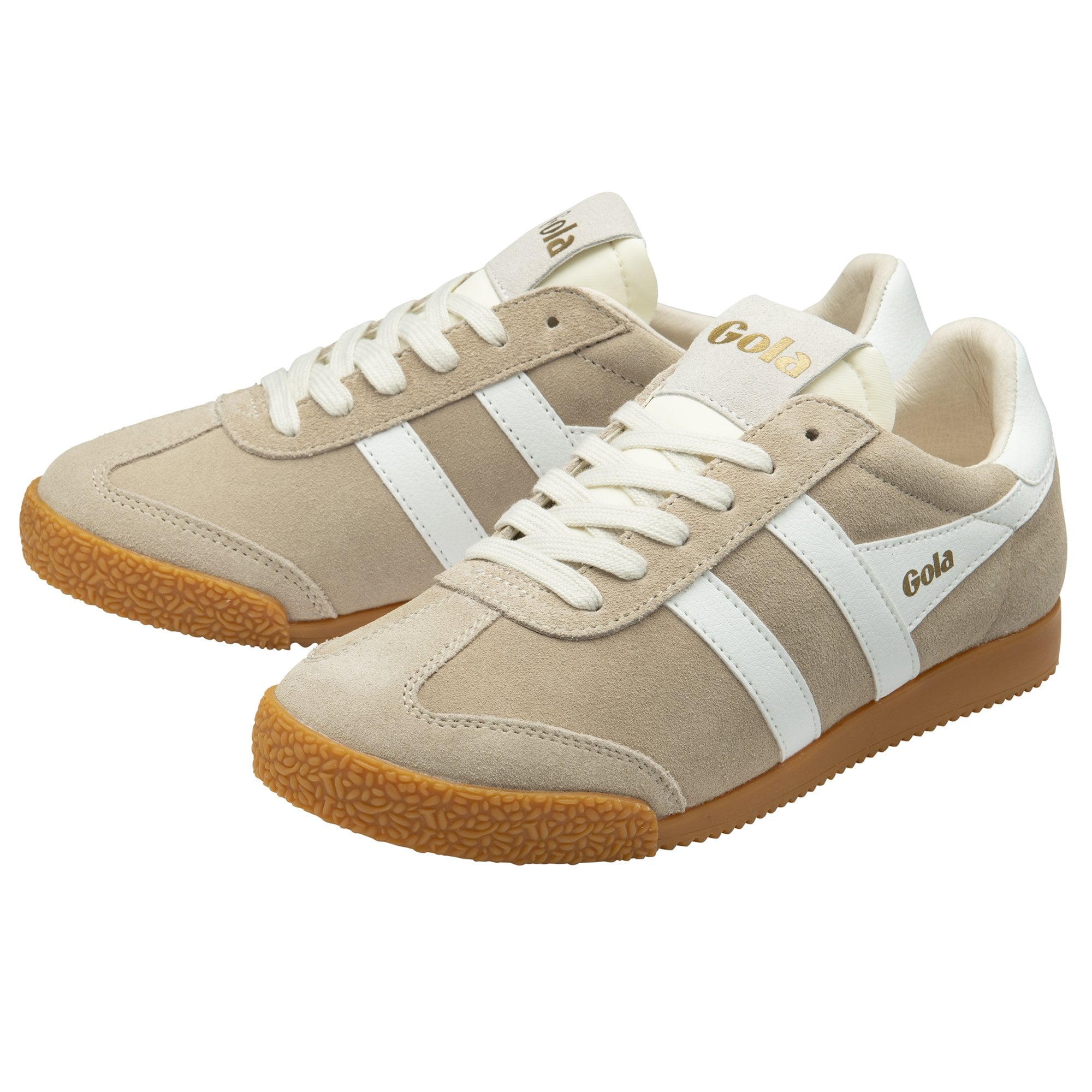 A pair of Gola Harrier trainers in off-white with white stripes, angled left.