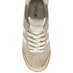 Top-down view of a single Gola Harrier trainer in off-white with white stripes.