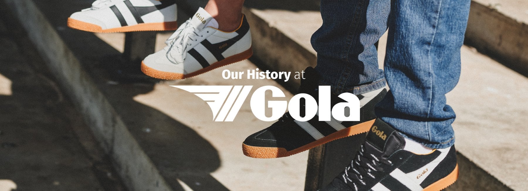 Three pairs of Gola sneakers on concrete steps. White and black shoes with orange soles.
