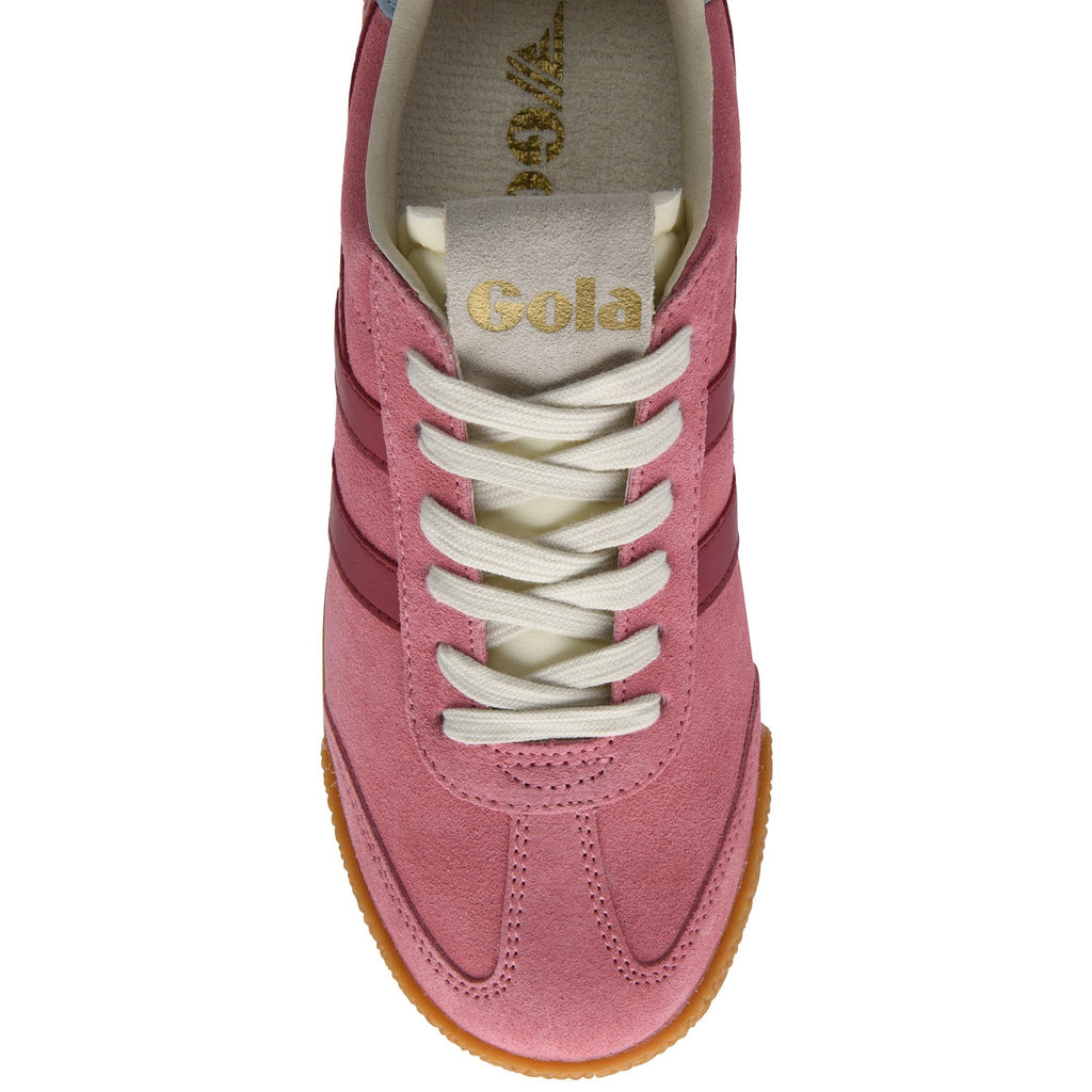 Close up of a pink suede trainer with white laces and a gum sole
