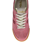 Close up of a pink suede trainer with white laces and a gum sole