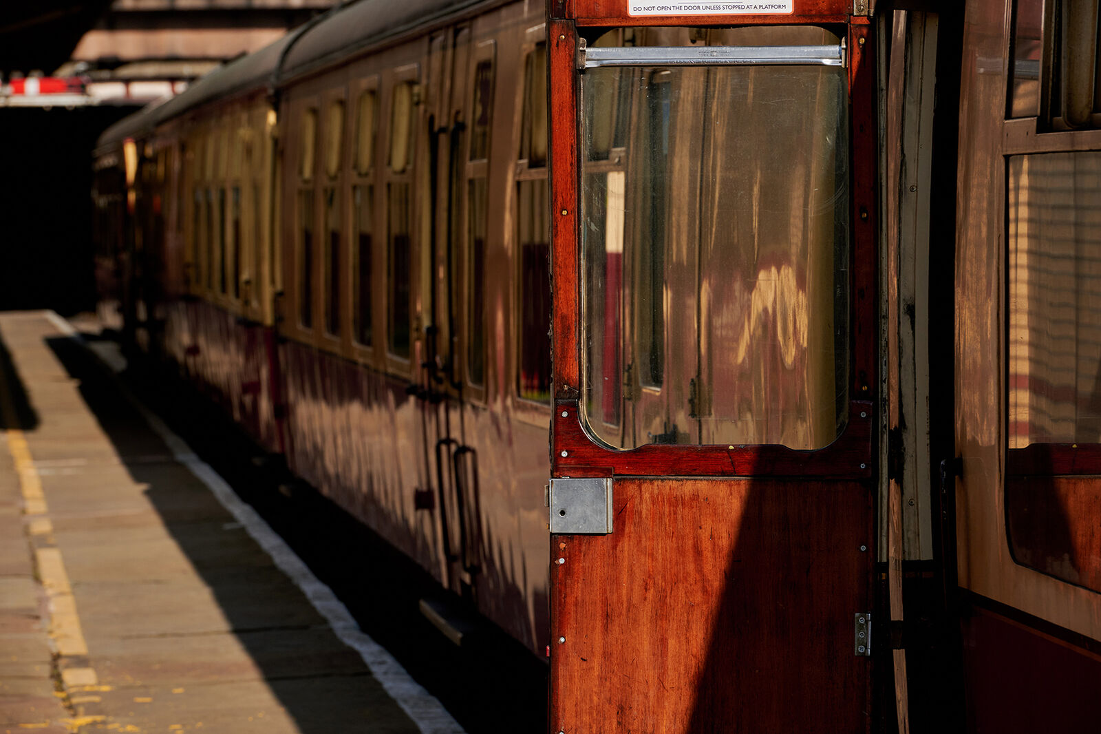 Vintage train carriage with open door at a station platform