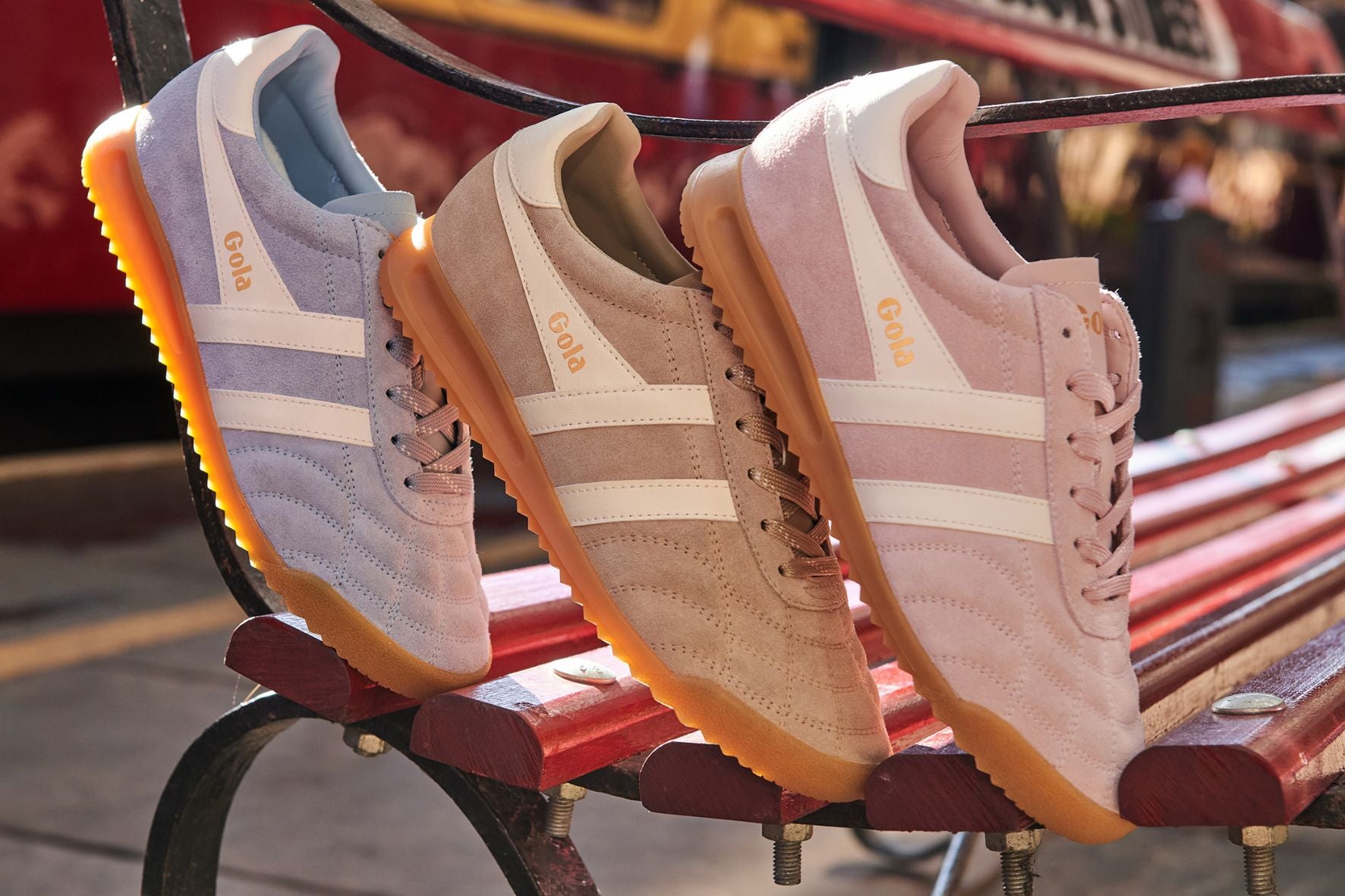Three trainers on a red bench with a blurred background